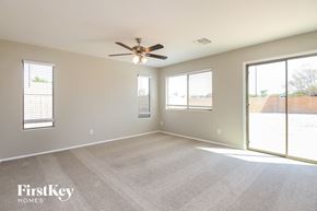San Tan Valley house for rent - A spacious room with a ceiling fan and sliding glass doors.