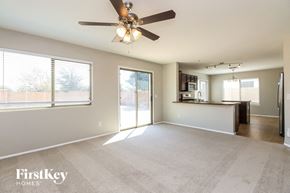 San Tan Valley house for rent - A spacious living room with a ceiling fan and sliding glass doors.