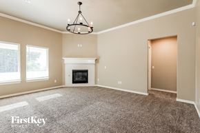 Edmond house for rent - an empty living room with a fireplace and a chandelier