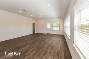Dickinson house for rent - A spacious room with wooden flooring and a large window with blinds.
