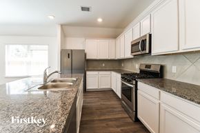 Dickinson house for rent - A kitchen with a granite countertop and stainless steel appliances.
