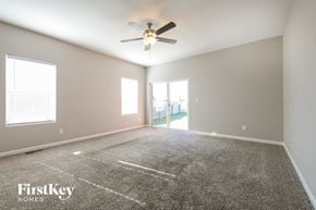 Thornton house for rent - the spacious living room with carpeted flooring and a ceiling fan