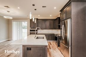 Orlando house for rent - A modern kitchen with a marble countertop and stainless steel appliances.