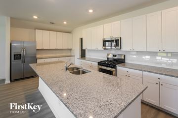 San Antonio house for rent - a large kitchen with white cabinets and granite counter tops