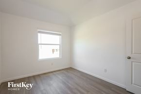 San Antonio house for rent - a bedroom with white walls and wooden floors and a window