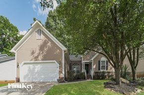 Charlotte house for rent - a house with a garage and a tree in front of it