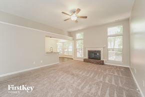 Charlotte house for rent - an empty living room with a ceiling fan and a fireplace