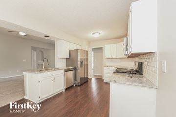 Charlotte house for rent - a kitchen with white cabinets and a stainless steel refrigerator