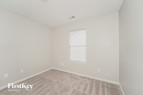 Charlotte house for rent - the bedroom of a home with a large window and carpet