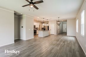 Tucson house for rent - A spacious room with a ceiling fan and pendant lights.