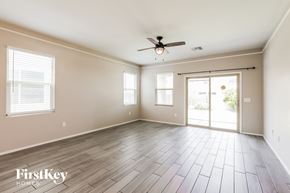 Tucson house for rent - A spacious room with a ceiling fan and sliding glass doors.