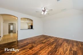 Fort Worth house for rent - A room with wooden floors and a ceiling fan.