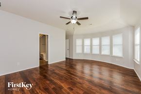 Fort Worth house for rent - A spacious room with wooden floors and a ceiling fan.