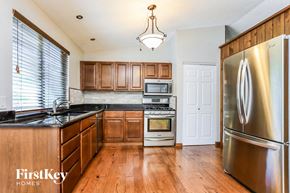 St Charles house for rent - a kitchen with wooden cabinets and stainless steel appliances