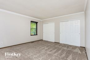 St Charles house for rent - a bedroom with white walls and carpet and two doors