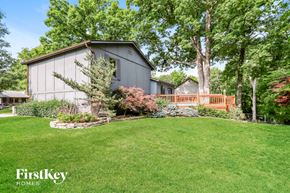 St Charles house for rent - a gray house with a wooden deck in the grass