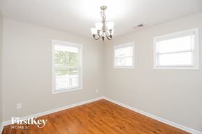 Cartersville house for rent - a empty dining room with a wood floor and a chandelier