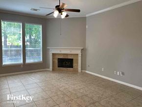 Spring house for rent - an empty living room with a fireplace and a ceiling fan