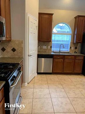 Spring house for rent - a kitchen with a stove and a sink and a window