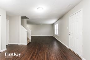 Indianapolis house for rent - A spacious room with wooden floors and white walls.