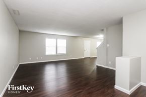 Indianapolis house for rent - A large empty room with wooden floors and white walls.