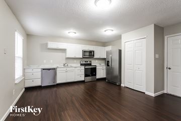 Indianapolis house for rent - A kitchen with white cabinets and a wooden floor.