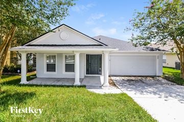 Groveland house for rent - a small white house with a driveway and a garage door