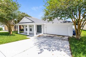 Groveland house for rent - a white house with a driveway and a white garage door