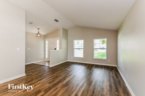 Groveland house for rent - the living room and dining room of an empty house with wood flooring