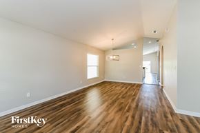 Groveland house for rent - the living room and dining room of an empty house with wood flooring