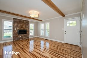 St Charles house for rent - an empty living room with a fireplace and wooden floors
