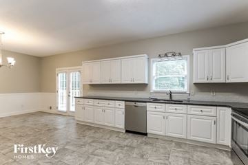 Gainesville house for rent - a kitchen with white cabinets and stainless steel appliances