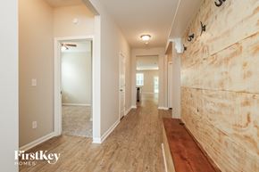 Moncks Corner house for rent - A long hallway with wood floors and a wood wall on the right side.
