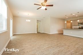 Moncks Corner house for rent - A spacious room with a ceiling fan and wooden flooring.