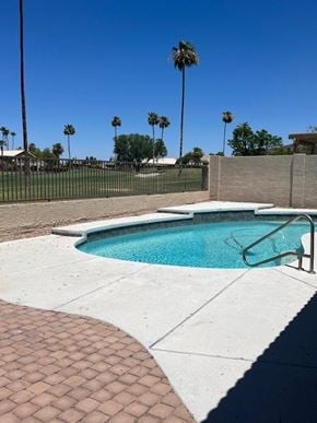 Glendale house for rent - a swimming pool with a fence and palm trees