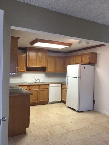 Clinton apartment for rent - a kitchen with a white refrigerator and wooden cabinets