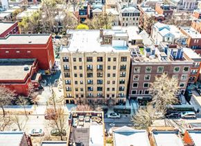 Chicago apartment for rent - A large building with a red roof is in the center of a city street.