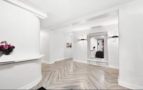 Chicago apartment for rent - A hallway with a herringbone patterned floor and white walls.