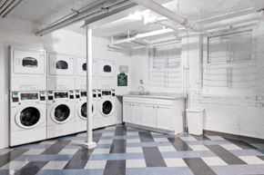 Chicago apartment for rent - an empty laundry room with white washing machines and a checkered floor