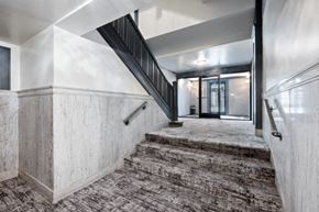 Chicago apartment for rent - the lobby of a building with stairs and a carpeted floor