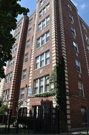 Chicago apartment for rent - A tall red brick building with ivy growing on the side.