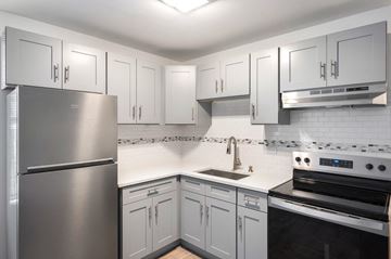 Chicago apartment for rent - a kitchen with white cabinets and stainless steel appliances