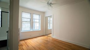Chicago apartment for rent - an empty living room with wood floors and a ceiling fan