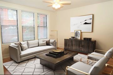 Chicago apartment for rent - A living room with a grey couch, a coffee table, and a painting on the wall.