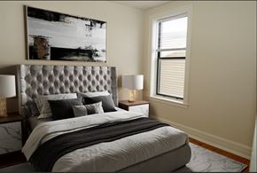 Chicago apartment for rent - A bedroom with a large bed and a painting on the wall.