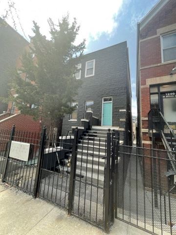 Chicago apartment for rent - a house with stairs and a fence in front of it