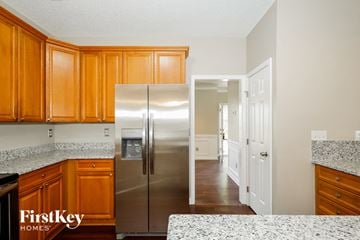 Indian Trail house for rent - A kitchen with wooden cabinets and a stainless steel refrigerator.
