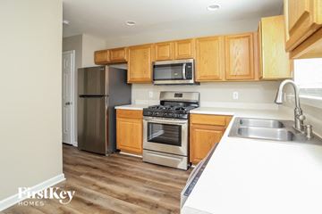 Woodstock house for rent - a kitchen with wooden cabinets and stainless steel appliances