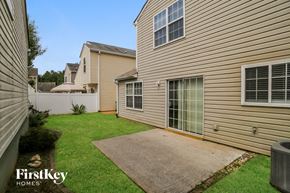 Woodstock house for rent - a backyard with a patio and a house with a yard and grass
