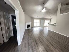 Lawrenceville house for rent - an empty living room with wooden floors and a ceiling fan